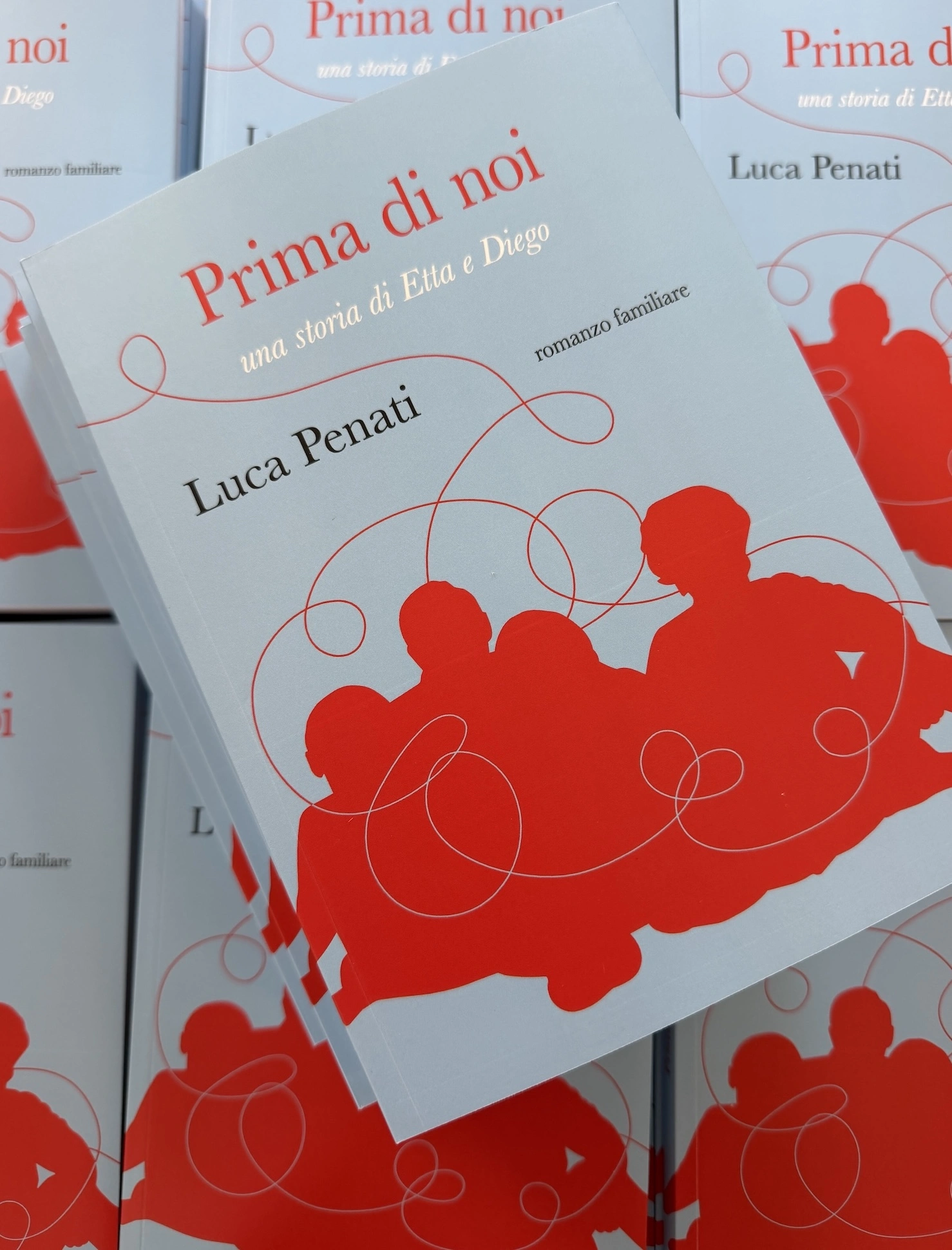 Alcune copie stampate di Prima di noi impilate su un tavolo Alcune copie stampate di Prima di noi impilate su un tavolo